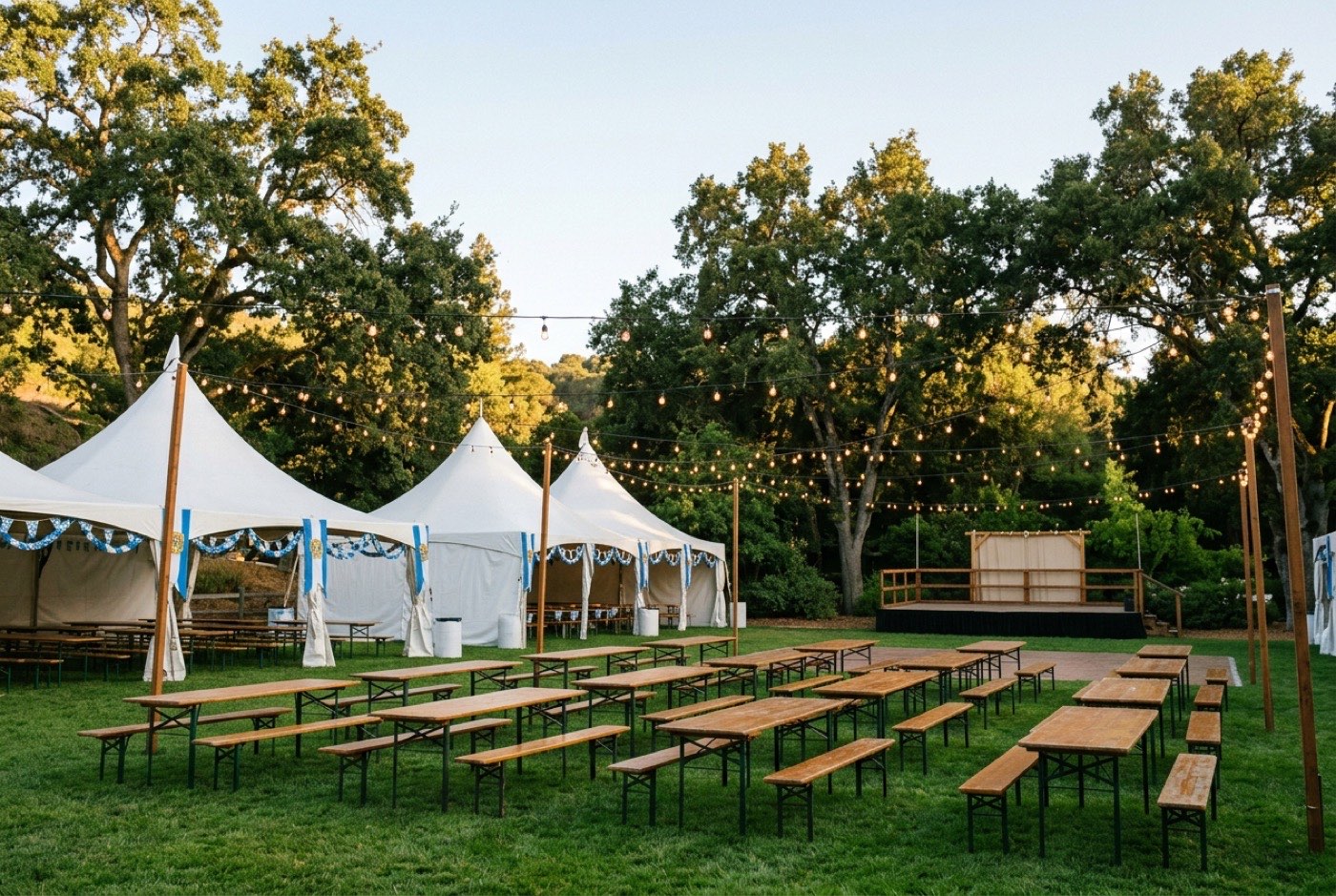 Festival tents, biergarten tables, and string lights on the lawn at Civic Park East in Walnut Creek under warm late-afternoon California light